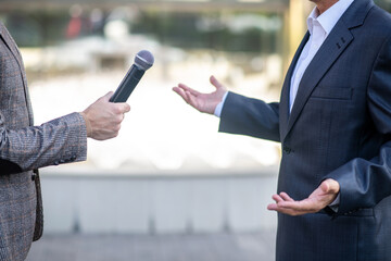 Close-up of male hands holding microphone during interview