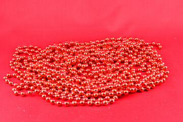 Christmas decorations, red beads, garlands, on a red background