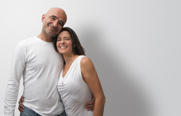 Obraz premium Attractive middle-aged Spanish couple showing love and happiness hugging.