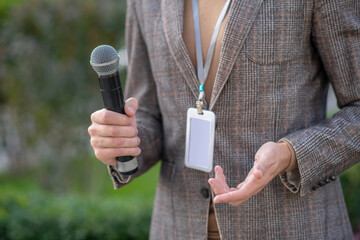 Close-up of male journalist hands holding microphone