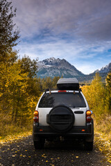Off Road Car in Autumn Forest in High Mountains. Outdoors Adventure and Road Trip. Social Distance
