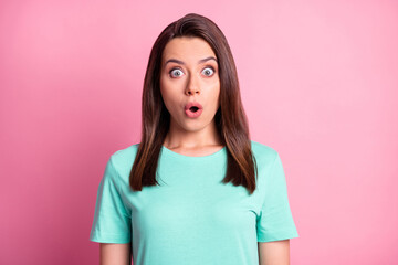 Portrait photo of shocked young woman starring with opened mouth isolated on pastel pink color background in turquoise t-shirt