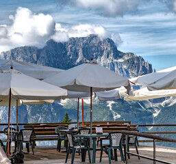 Terrazza panoramica di un bar ristorante sulle dolomiti, con tavolini e sedie
