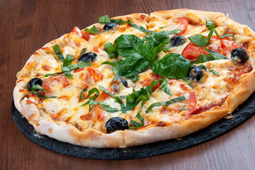Pizza with salami and basturma, onions and basil