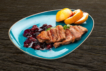 Magre duck breast with baked apple and berry sauce. On a decorative plate