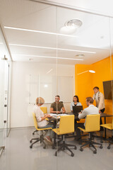 Vertical full length shot of a business team having a meeting in meeting room, copy space