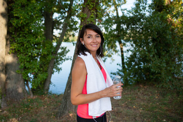 beautiful woman drinking mineral water in a bottle during running sport fitness and exercising outdoor