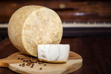 Cheese with coffee beans on a wooden plank. the background. Close-up