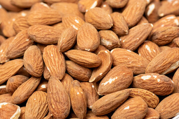 Natural food background of big raw peeled almonds, closeup organic fresh tasty nuts, delicious snack, cooking baking ingredients. Nuts texture closeup. Healthy vegetarian food concept, text space