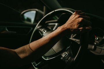 Woman hand holding car steering wheel while she drives.