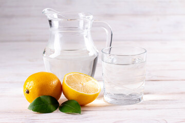 Naklejka na ściany i meble Glass of water with lemon on white wooden table