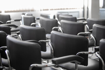 Empty black chairs stand in conference hall