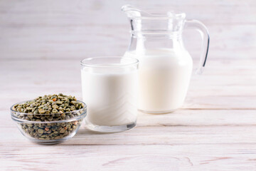 Vegetable pea milk in a milk jug and peas in a jar. Gluten-free, lactose-free product. Copy space.
