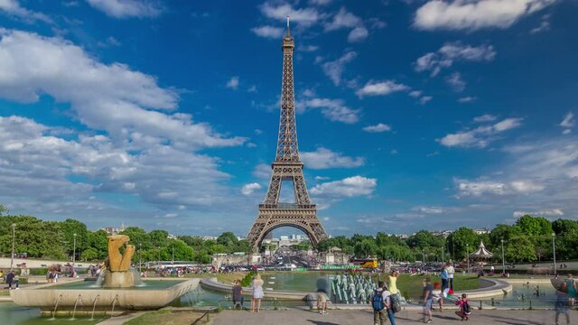 Fountains on famous square Trocadero with Eiffel tower in the background timelapse hyperlapse. Trocadero and Eiffel tower are the most visited attractions of Paris. Blue cloudy sky at summer day