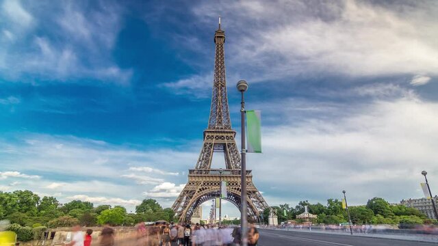 Eiffel Tower view from the Bridge of Jena timelapse hyperlapse, Paris, France. Blue cloudy sky at summer day and traffic on the road