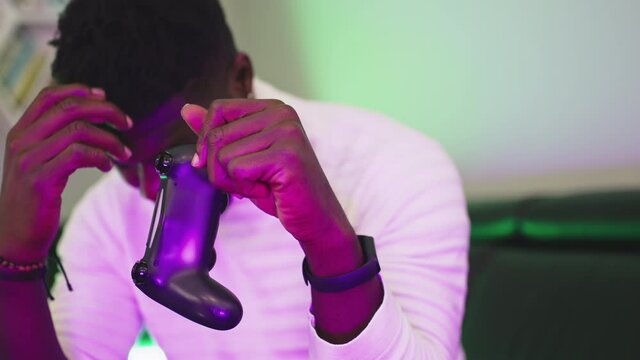 Black man playing game usig console controlling joystick. Entertainment during the lockdown. Lost game. High quality 4k footage