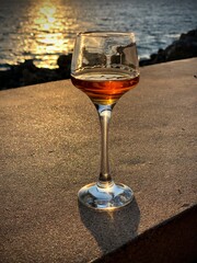 Shot of rum or cognac on the sunset background 