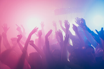 Photo of big group many people funky raise arms stage event concert floor neon bright pink spotlight modern club indoors