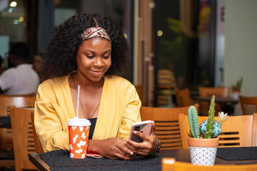 image of beautiful african lady, with smart phone, food and drink concept