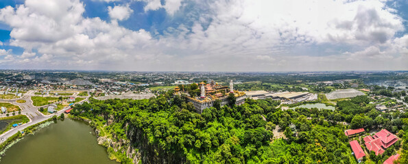 Aerial view of bodhisattva architecture and double sky dragon in Chau Thoi pagoda, Binh Duong province, Vietnam in the afternoon with sun through cloud create auspicious buddha.