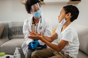 Female doctor and boy during examining at home