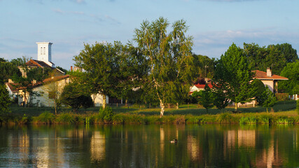 Fototapeta na wymiar Ambiance romantique et chaleureuse au bord d'un lac, dans un village des Landes