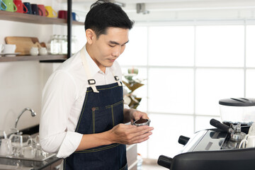 Fototapeta premium Asian barista man holding a coffee tamper in the coffee shop