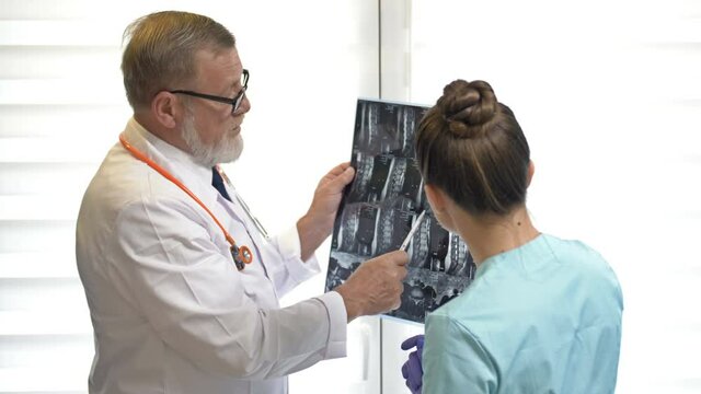 Two doctors examining x-ray images of patient for diagnosis.