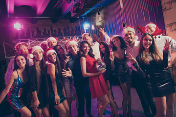 Photo portrait of people posing wearing santa claus reindeer headwear holding disco ball at party