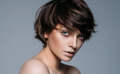 Fotobehang Kapsalon Portrait of a young brunette girl with stylish short hair  © kiuikson