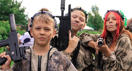 Children playing in lasertag shooting game in open air. Weapon in the hands of people. War...