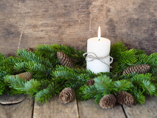 Postcard. Spruce branches are laid out around a lit New Year's candle. Christmas still life. Place for your text.