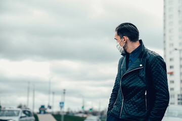 Obraz premium man in a protective mask looks at the empty street