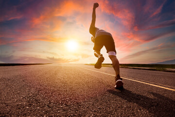 Fototapeta na wymiar man running and sprinting on road with sunset background