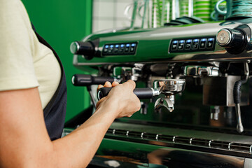 Woman coffee shop worker preparing coffee on professional coffee machine