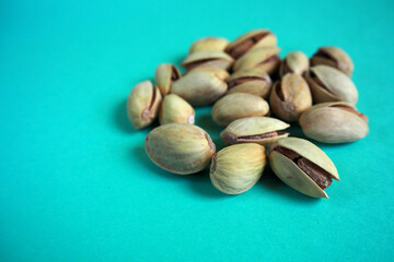 several pistachios lie on a turquoise background side view . grain kind of pistachio