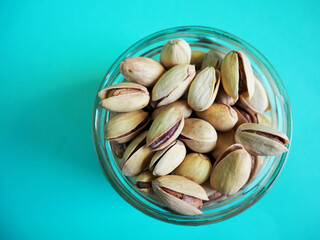 small glass jar filled with pistachios top view . grain kind of pistachio