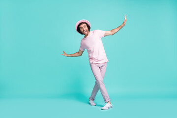 Full length photo of adorable guy dancing wear cap t-shirt trousers sneakers isolated on teal color background