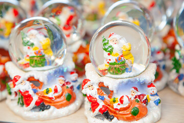 Various traditional Christmas balls with water inside and Santa Claus. Christmas showcase in supermarket, home decoration
