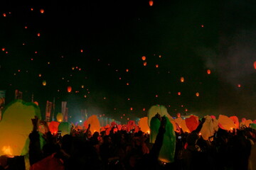 People fly paper lanterns at a Culture Festival with many colorful lanterns fly in the sky.