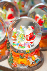 Various traditional Christmas balls with water inside and Santa Claus. Christmas showcase in supermarket, home decoration