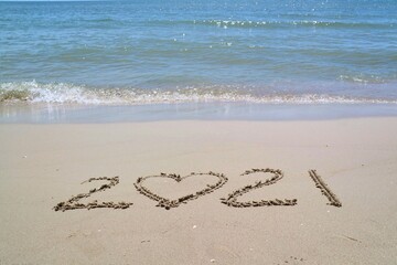 Happy New year 2021 with the waves beat at the beach and shell fragments. Soft focus. Holiday and nature concept.
