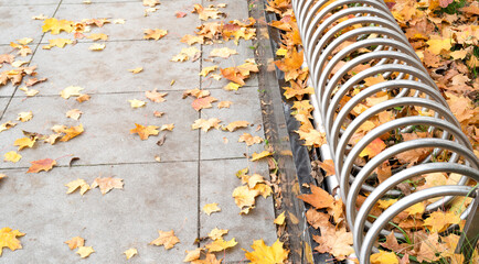pusty stojak na rowery wsród jesiennych liści - obrazy, fototapety, plakaty