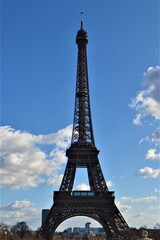 City sign of the Paris, France: Eiffel. Statue of Eiffel made of full metal and steel, Paris ,France during light cloudy day and blue sky. 