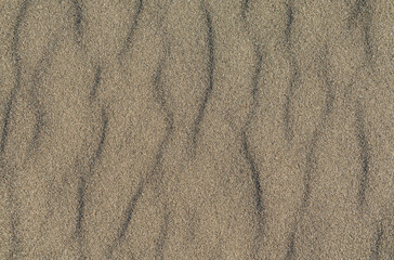 Closeup of volcanic sand pattern of a beach in the summer
