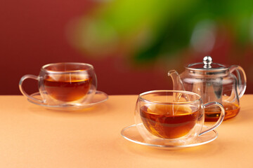Glass teapot and two glass cups with tea