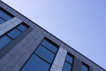 Fototapeta na wymiar Part of the building with Windows, blue sky, diagonal.