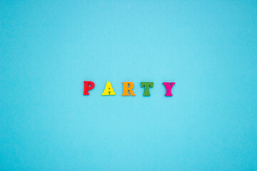 The word PARTY on a blue background of wooden multicolored letters.