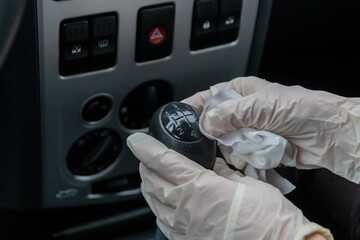 Child hand in rubber glove disinfects car gear stick infection control and infection prevention for...
