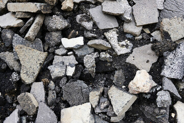 Broken pieces of asphalt at a construction site. Recycling and reuse crushed concrete rubble, asphalt, building material, blocks. Crushed сoncrete Background. 
